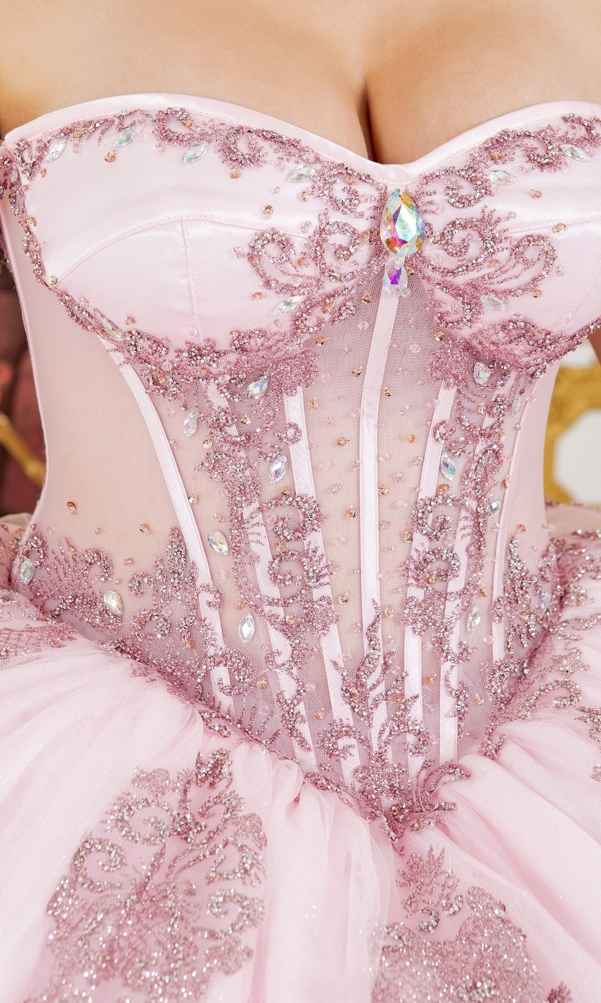 Close-up of the Quinceanera Dress 8190J by Cinderella Couture, showcasing pastel hues with glittery embroidery, sequins, and a gemstone accent at the center of the bodice.